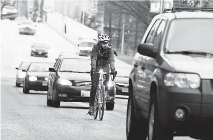  ?? LLOYD FOX/BALTIMORE SUN ?? A cyclist rides with traffic down Maryland Avenue in Baltimore in this 2015 photo.