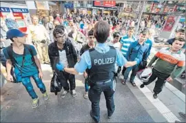  ?? Matthias Balk European Pressphoto Agency ?? MIGRANTS are shown to a registrati­on office at a Munich train station. In Germany, which plans to take in 800,000 refugees, arson fires have damaged shelters.