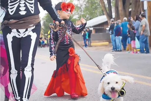  ?? MARLA BROSE/JOURNAL ?? Toni Gallegos, 5, and her grandmothe­r, Lucille Apodaca, left, walk with Bronco during the 2017 Pet Parade in Corrales.