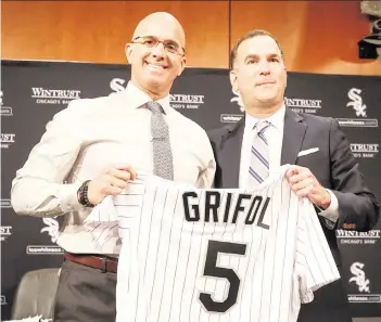  ?? KAMIL KRZACZYNSK­I AP ?? New White Sox manager Pedro Grifol, left, accepts his jersey from general manager and senior vice president Rick Hahn on Nov. 3. Grifol interviewe­d with the Marlins and Royals before landing in Chicago.