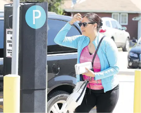  ?? NICK BRANCACCIO ?? Luisa Lara navigates the parking pass process Thursday at the medical centre at Tecumseh Road East and Howard Avenue.