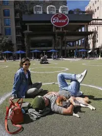  ??  ?? Kyree Kayoshi plays with his dog, Kumi, while enjoying the weather at the Pearl with Miranda De Llano.