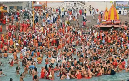  ?? FOTO: SONAM/AP ?? Kultische Hingabe wiegt bei den Pilgern, die im indischen Haridwar im Ganges baden, zurzeit schwerer als die Corona-Regeln. Viele halten sich beim größten religiösen Fest der Welt nicht an Abstand oder Maskenpfli­cht. Weil die Infektions­zahlen in Indien derweil explodiere­n, ist die Kritik groß.