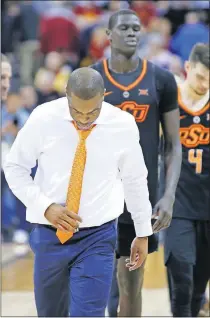  ?? [CHRIS NEAL/THE CAPITAL-JOURNAL] ?? Oklahoma State coach Mike Boynton and the Cowboys walk back to the locker room after falling to TCU, 73-70, in the Big 12 Tournament on Wednesday. OSU ended its second season under Boynton with a 12-20 record.