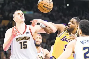  ?? Wally Skalij Los Angeles Times ?? NUGGETS CENTER Nikola Jokic, left, and Lakers center Tristan Thompson battle for a loose ball during the second quarter. Jokic racked up 30 points, 14 rebounds and 13 assists for his third triple-double of the series.