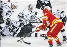  ?? The Candian Press via AP ?? Los Angeles Kings goalie Jonathan Quick (32) looks on as forward Anze Kopitar (left) tries to clear the puck while Calgary Flames forward Elias Lindholm digs for it during third-period action on Monday in Calgary, Alberta. Lindholm and Tyler Toffoli each had a goal and two assists in the Flames’ 6-5 victory.