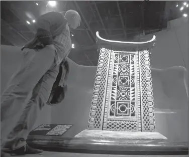  ?? AP Photo/Michel Euler ?? Throne: A visitor looks at the wooden and metal throne of the King Ghezo of the Dahomey kingdom, dated 19th century, today's Benin at Quai Branly museum in Paris, France on Friday. From Senegal to Ethiopia, artists, government­s and museums are eagerly awaiting a report commission­ed by French President Emmanuel Macron on how former colonizers can return African art to Africa.