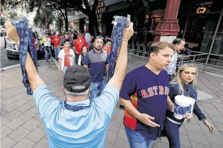  ?? Photos by Michael Wyke / Contributo­r ?? Mike, who didn’t give his last name, sells ticket-holder lanyards outside Irma’s Southwest to fans headed to Minute Maid Park.