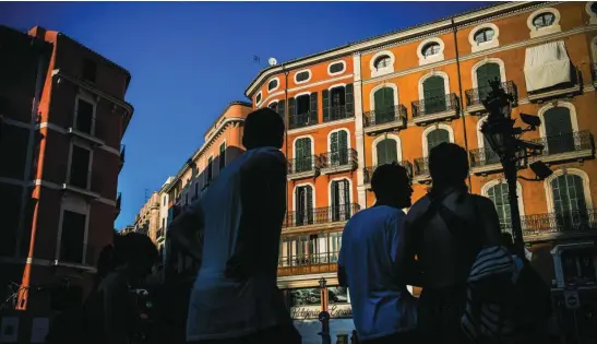  ?? ALBERTO R. ROLDÁN ?? Turistas frente a un bloque de viviendas en Palma de Mallorca
