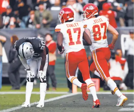  ?? Photos by Scott Strazzante / The Chronicle ?? Kansas City’s Chris Conley and Travis Kelce run past Raiders cornerback Daryl Worley after a TD reception by Kelce.