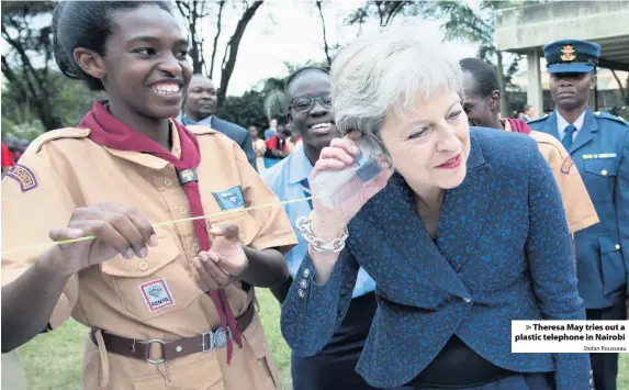  ?? Stefan Rousseau ?? &gt; Theresa May tries out a plastic telephone in Nairobi