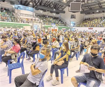  ?? ACHADTHAYA CHUENNIRAN ?? People wait to be vaccinated against Covid-19 at a gymnasium in Saphan Hin, in Phuket. The province is vaccinatin­g local people ahead of reopening to foreign tourists in July.