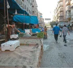  ??  ?? Des passants marchent devant les étals vides de marchands dans les rues d’un quartier d’Alep contrôlé par les rebelles.