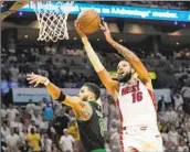  ?? Lynne Sladky Associated Press ?? CALEB MARTIN, who scored 18 points for Miami, drives to the basket on Boston’s Jayson Tatum.