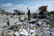  ?? HASSAN AMMAR, FILE — THE ASSOCIATED PRESS ?? A Syrian soldier films the damage of the Syrian Scientific Research Center which was attacked by U.S., British and French military strikes to punish President Bashar Assad for suspected chemical attack against civilians, in Barzeh, near Damascus, Syria.