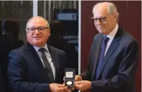  ?? ?? Prof. Edward Scicluna presented a commemorat­ive coin to Prof. Joachim James Calleja, Principal and CEO at MCAST.