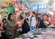  ?? AFP ?? EXPRESSING SUPPORT: Supporters of Nabil Karoui pose for a group picture as they hold up his electoral posters at a fish market in the northern city of Bizerte on Thursday. —