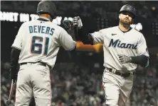  ?? Thearon W. Henderson / Getty Images ?? Miami’s Jose Devers congratula­tes Jon Berti after his solo home run tied the game in the seventh inning.