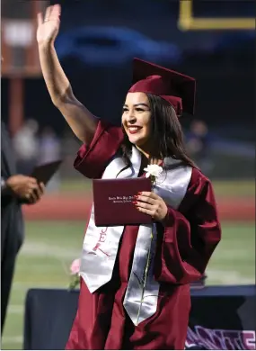  ?? RECORDER PHOTOS BY CHIEKO HARA ?? Elva Munguia, above, waves to her family and friends in the bleachers after receiving her diploma Wednesday, June 6, at the Granite Hills High School Commenceme­nt at Jacob Rankin Stadium in Portervill­e. Graduates were congratula­ted by faculty members,...