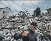  ?? Marcus Yam Los Angeles Times ?? A SECURITY GUARD passes the rubble of a police station destroyed in a bombardmen­t in Lysychansk.