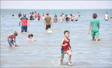  ??  ?? Iraqi youths and children swim in the waters of Lake Habbaniyah.