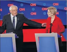  ??  ?? Sen. Bernie Sanders, I-Vt., gestures toward Sen. Elizabeth Warren, D-Mass., during the first of two Democratic presidenti­al primary debates hosted by CNN on Tuesday in the Fox Theatre in Detroit. [AP PHOTO/PAUL SANCYA]