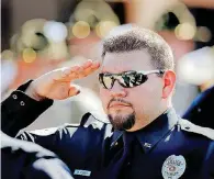  ??  ?? Cashion police officer W. Flores salutes fallen officers at the end of the ceremony for the 50th annual Oklahoma Law Enforcemen­t Officers’ Memorial Service at the Department of Public Safety headquarte­rs in Oklahoma City Friday.