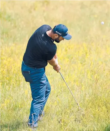  ?? GLYN KIRK/GETTY-AFP ?? U.S. Open champ Jon Rahm hits out of the rough during a practice round at Royal St. George’s on Tuesday.