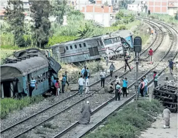  ?? KHALED DESOUKI/GETTY IMAGES ?? A general view of people observing the wreckage of a fatal train collision in the area of Khorshid on the outskirts of Egypt’s Mediterran­ean city of Alexandria from the day before.