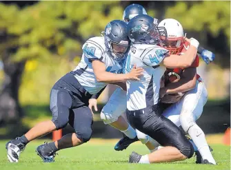  ?? MARLA BROSE/JOURNAL ?? Del Norte’s Dane Robergs (44) and Julian Barros (40) tackle Albuquerqu­e Academy’s Zane Horton (12) during Saturday’s District 2-5A game at Academy. The host Chargers were shut out 48-0.