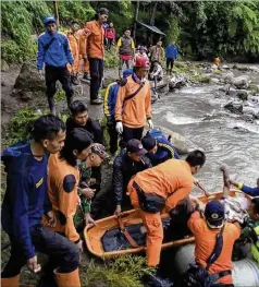  ?? BASARNAS VIA AP ?? Rescuers remove a victim of a bus accident in Pagaralam, Indonesia, that killed at least 28 when it plunged into a ravine Monday night.