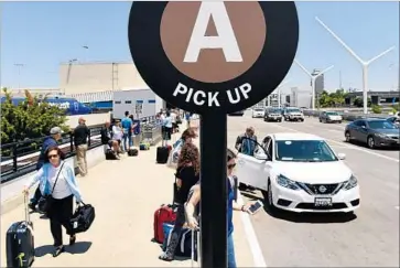  ?? Wally Skalij Los Angeles Times ?? UBER, which first launched its service in San Francisco in July 2010, now has more than 12,000 employees and serves more than 600 cities worldwide. Above, customers wait for rides at Los Angeles Internatio­nal Airport.