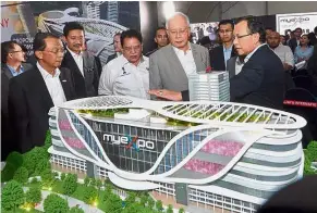  ?? — Bernama ?? New space: Najib listening to Putrajaya Corporatio­n president and PULSE group chairman Datuk Seri Hasim Ismail (right) about the MyExpo centre during its opening at Presint 5, Putrajaya. Looking on is Federal Territory Minister Datuk Seri Tengku Adnan...