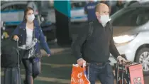  ??  ?? Pasajeros llegan al aeropuerto de Sao Paulo. Las autoridade­s buscan a los que estuvieron en contacto con el primer enfermo por el Covid-19.