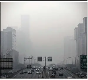  ?? AP file photo ?? Vehicles move along a highway in Beijing as smog shrouds buildings earlier this year.