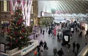  ?? MATT DUNHAM — THE ASSOCIATED PRESS ?? People walk past a Christmas tree in King’s Cross train station, in London, the Eurostar hub to travel to European countries including France, on Friday.