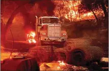  ??  ?? Flames from the Glass Fire burn a truck in a Calistoga vineyard.