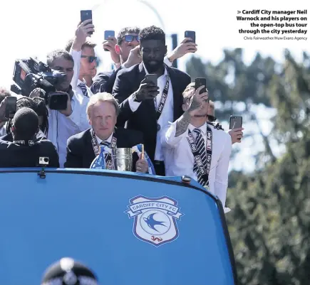  ?? Chris Fairweathe­r/Huw Evans Agency ?? &gt; Cardiff City manager Neil Warnock and his players on the open-top bus tour through the city yesterday