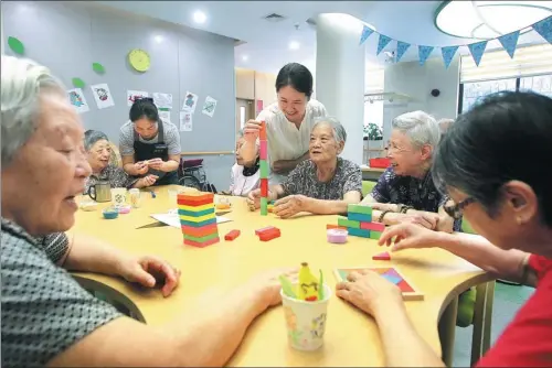  ?? JIANG DIWEN / FOR CHINA DAILY ?? Elderly residents enjoy an afternoon playing with puzzles at the Jiangjiaqi­ao respite care center in Hongkou district, Shanghai.