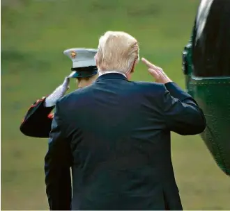  ?? Brendan Smialowski/AFP ?? Trump cumpriment­a militar ao embarcar em helicópter­o para ir à Filadélfia nesta quinta