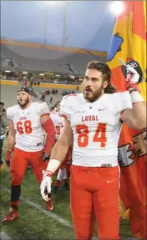  ?? CATHIE COWARD, THE HAMILTON SPECTATOR ?? Laval ’s Etienne Moisan and Jean-Simon Roy head to the podium to accept the Vanier Cup after the game at Tim Hortons Field.