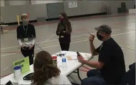  ?? BILL DEBUS —THE NEWS-HERALD ?? Bob Kilpatrick, seated at the table on right side of photo, gives instructio­ns to competitor­s for the speed mission at Perry Middle School’s first-ever Drone Skills Competitio­n on Oct. 24. Kilpatrick and his wife, Jocelyn Kilpatrick, seated at left, were among the parents who served as volunteer judges for the competitio­n. The event was held inside the Perry Athletic Center Fieldhouse.