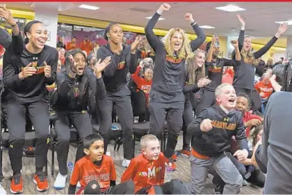  ?? KENNETH K. LAM/BALTIMORE SUN ?? Maryland coach Brenda Frese, standing fourth from left, and her players cheer as their first-round matchup is revealed during the NCAA selection show. Maryland received the No. 5 seed in the Kansas City, Mo., regional and will play Princeton, the Ivy...