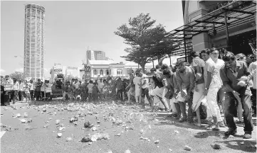  ??  ?? Hindu devotees smash coconuts during the maiden golden chariot procession. — Bernama photo