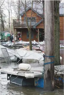  ?? PHOTOS ANNIK MH DE CARUFEL LE DEVOIR ?? «L’eau a monté jusqu’au plafond de notre salle familiale», a raconté aux journalist­es Mina Tayarani, de L’Île-Bizard, chez elle sur notre photo. À gauche: des débris jonchent une rue de l’île Mercier.