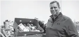  ?? MAX SMITH • SPECIAL TO THE GUARDIAN ?? Upper Room Hospitalit­y Ministry executive director Mike MacDonald looks over some of the donations received during the recent Y’s Service Club food drive.