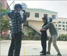  ??  ?? Top: Members of the Beijing SWAT team take part in a training exercise. The team’s movie on Douyin has gained more than 8 million likes from viewers. Above: A policewoma­n from the Guangxi Zhuang autonomous region shoots a video to teach women...