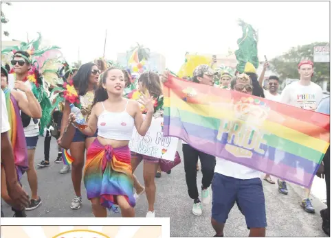  ?? (Terrence Thompson photo) ?? Draped in the rainbow colours of the LGBT flag, a reveller enjoys herself as the Pride Parade moves along Church Street.