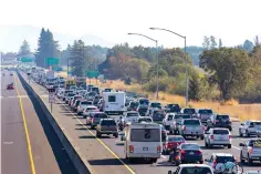  ?? Darryl Bush/The Press Democrat via AP ?? ■ BELOW LEFT: Traffic is backed up heading South on Highway 101 Saturday during mandatory evacuation­s due to predicted danger from the Kincade Fire in Windsor, Calif.