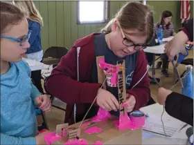  ?? RENEE BORCAS — THE NEWS-HERALD ?? Girl Scouts work together at Geauga County Public Library’s Badge-in-a-Day event on Feb. 15 to earn a Junior Crane Design Challenge Badge.